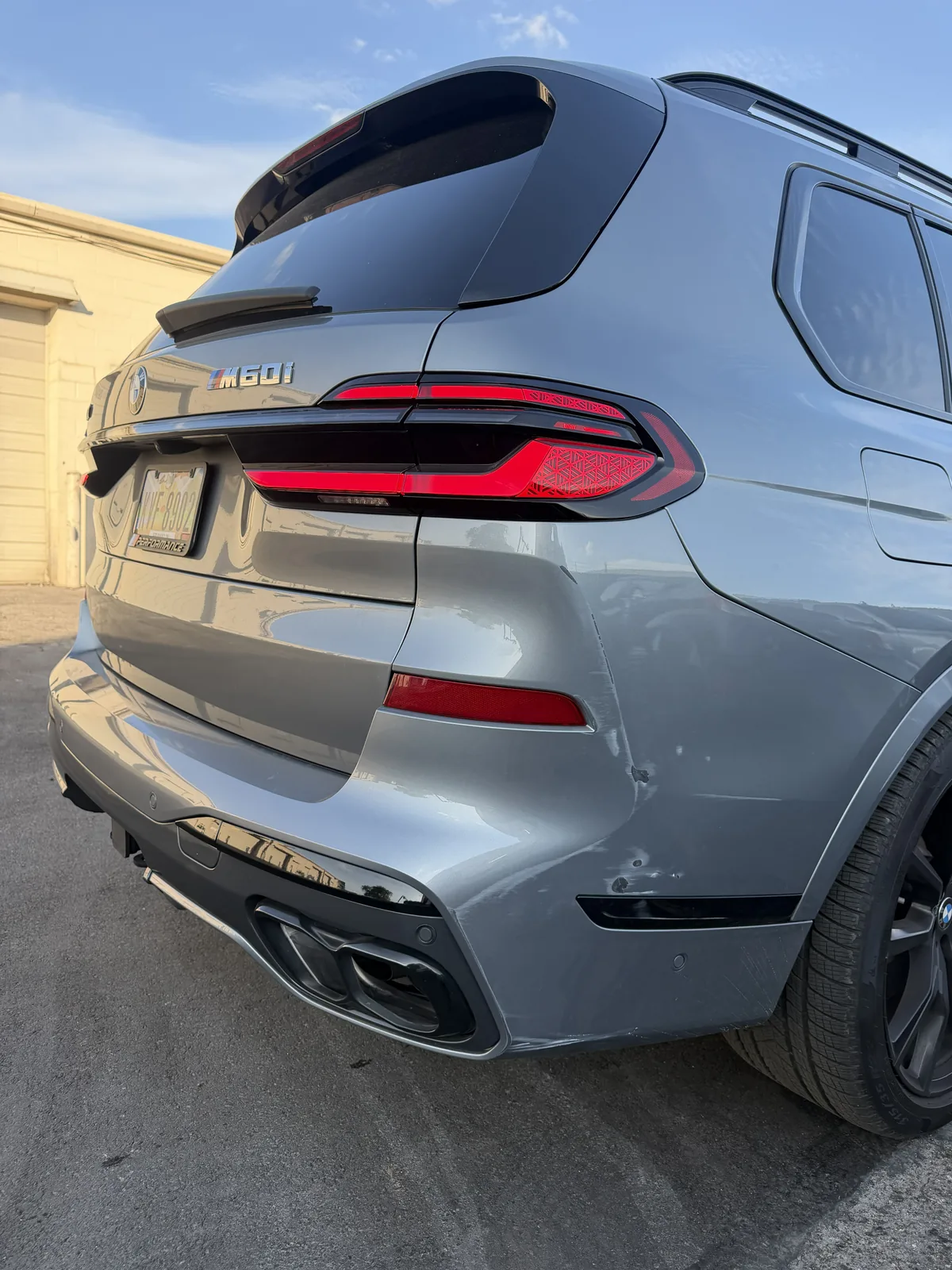 Gray BMW X7 M60i rear end at dusk outside the shop