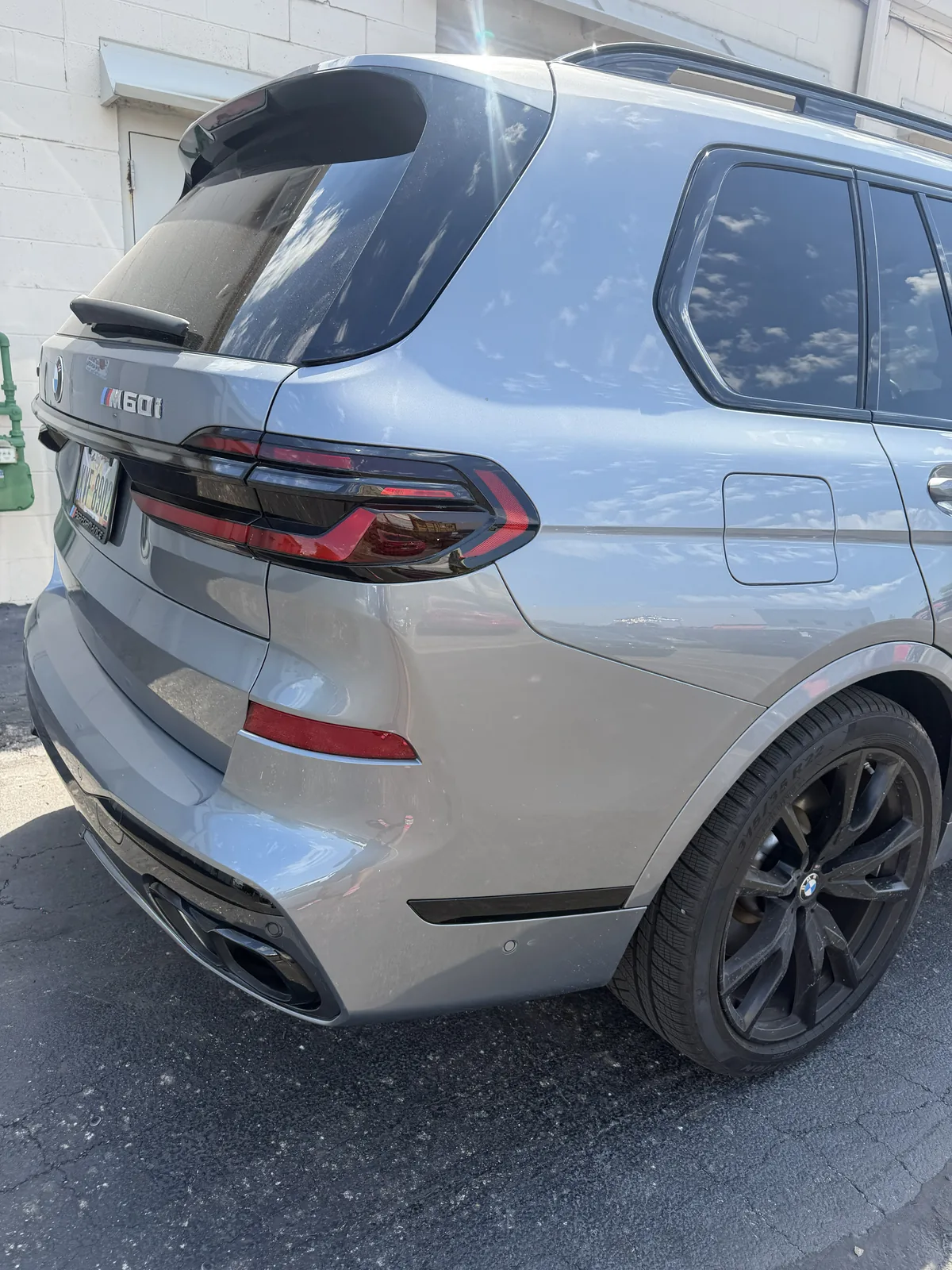 Gray BMW X7 M60i rear quarter in daylight