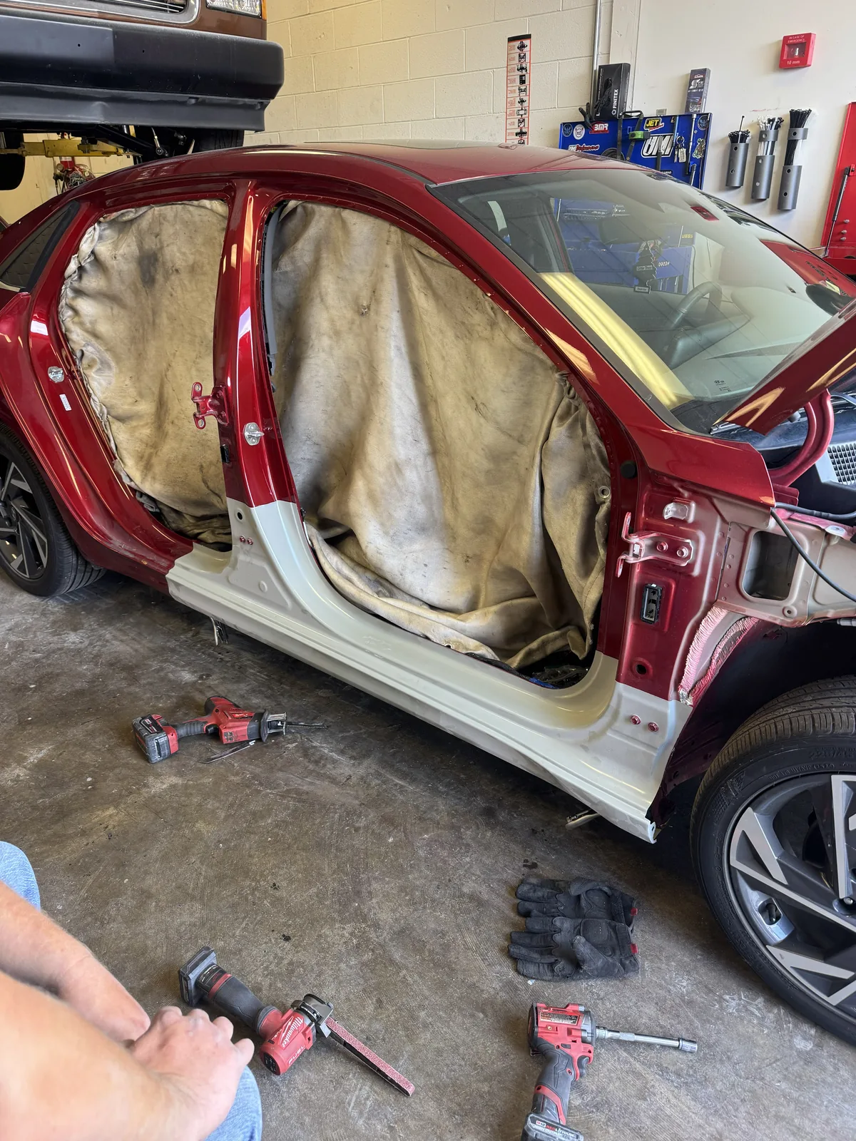 Red Hyundai sedan with rocker and pillar in white primer