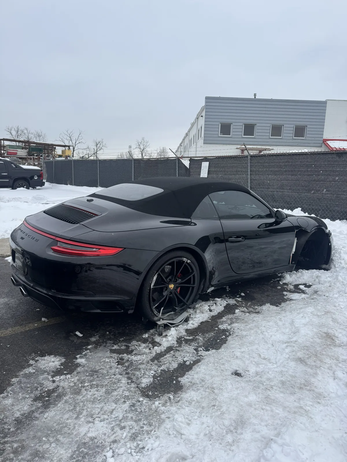 Rear three quarter view of black Porsche 911 cabriolet